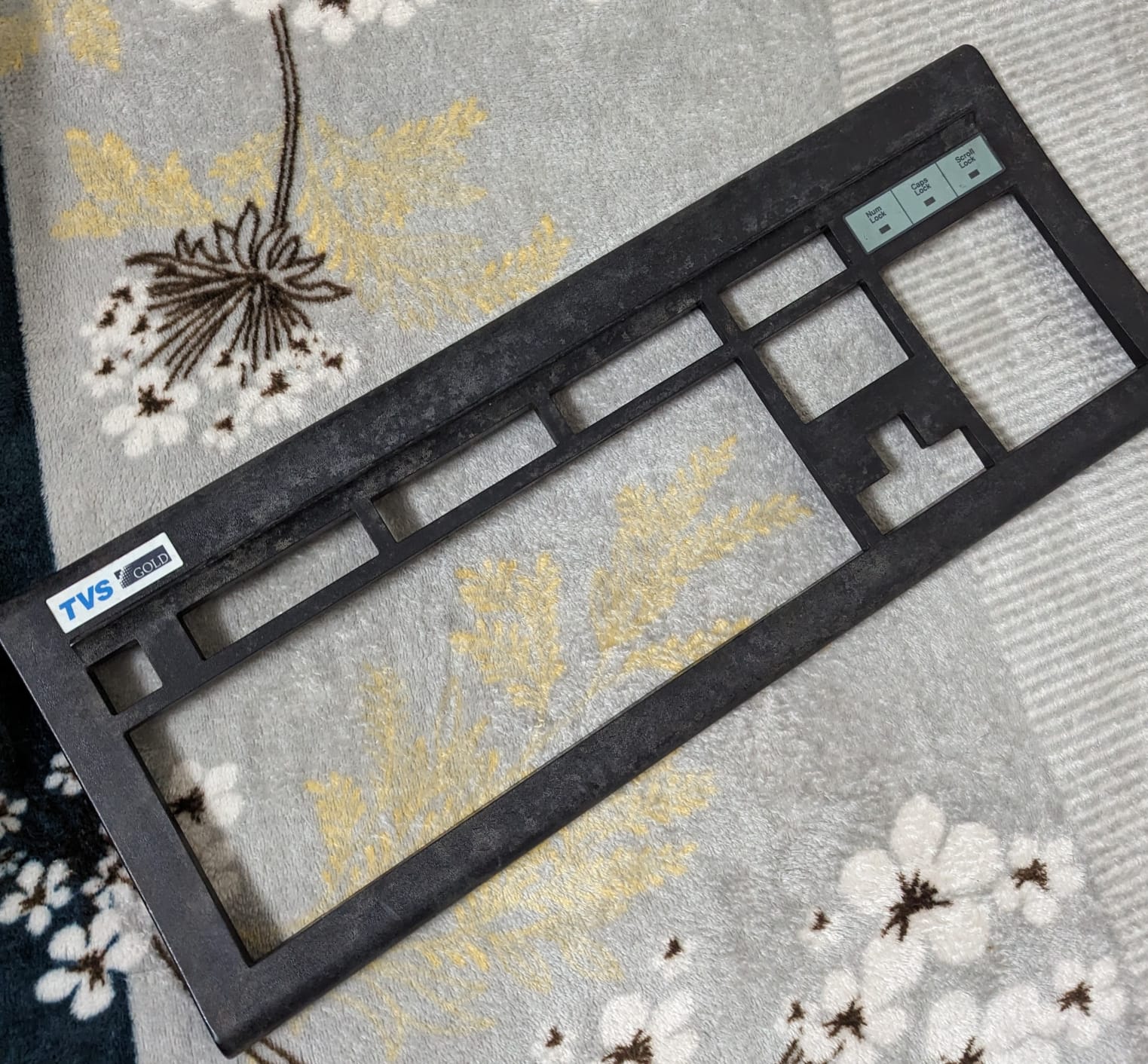 The discolored and degraded plastic frame of the keyboard.